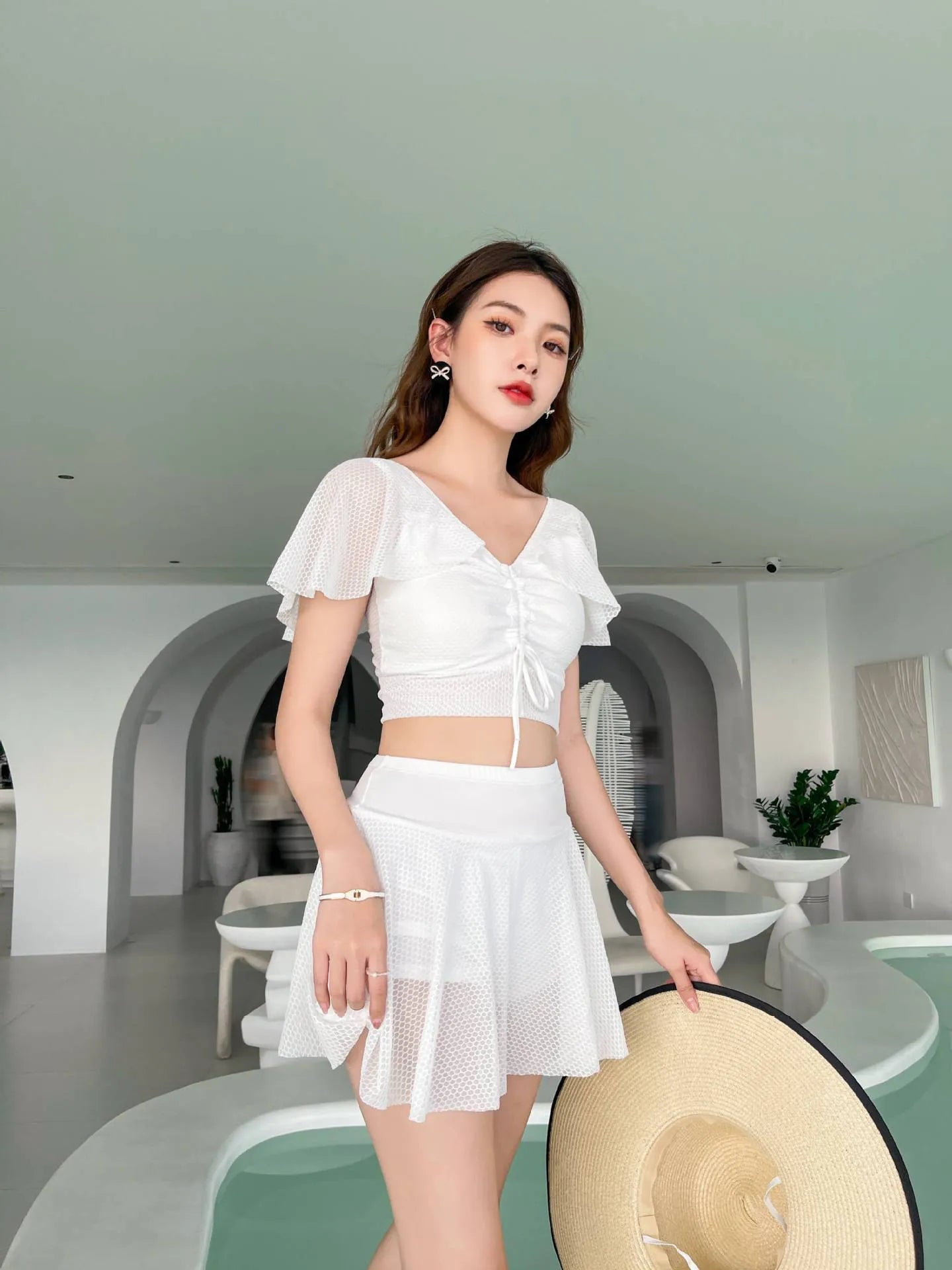 Women's two-piece swimwear set with matching top and skirt in solid colour