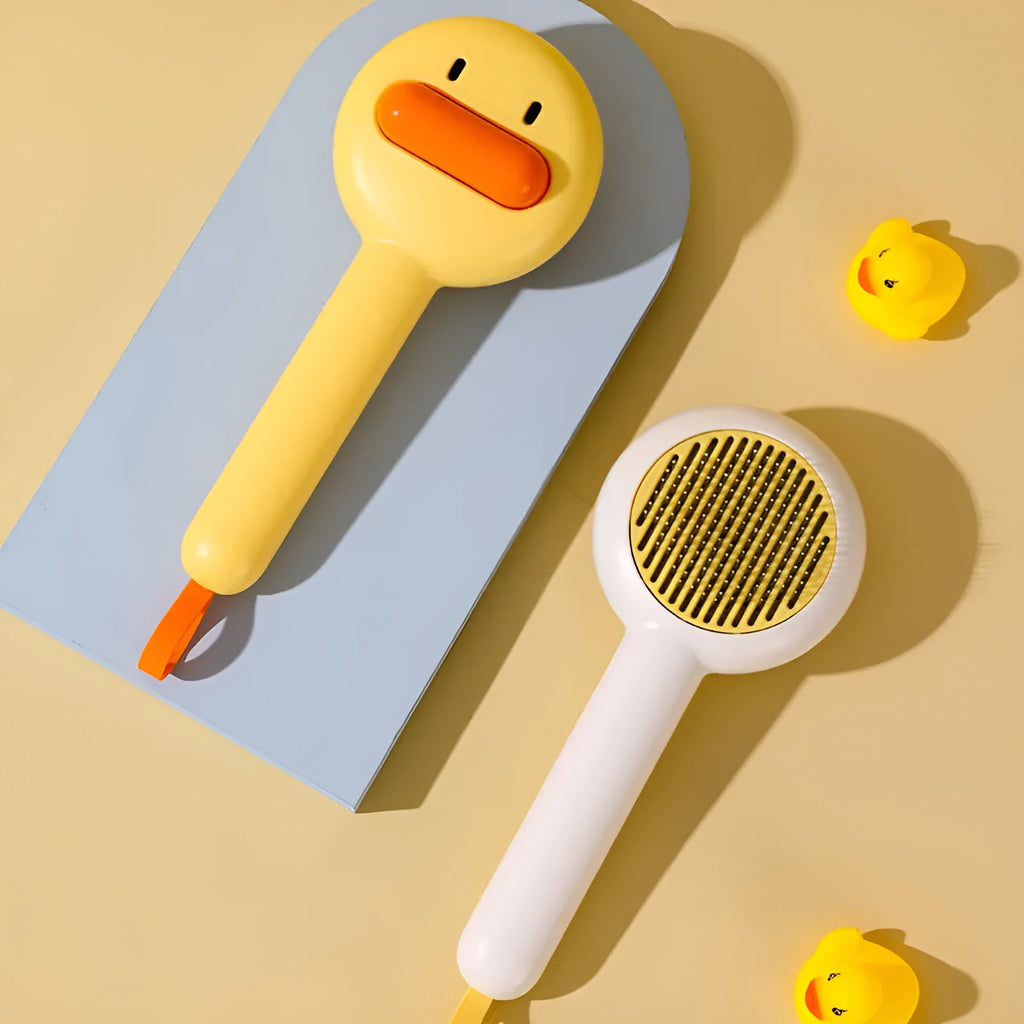 Small yellow and white pet grooming comb with needle teeth for cat and dog hair removal.