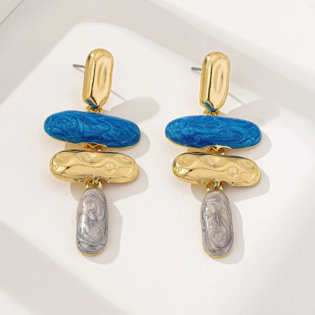 A pair of geometric multicolour stud earrings for women on a plain background.