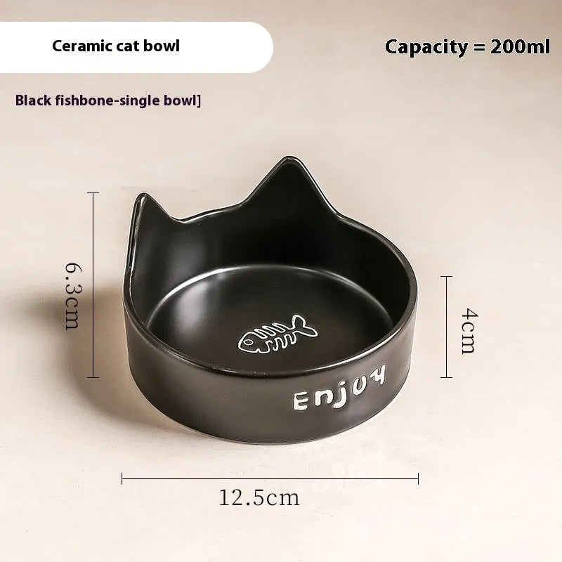 Porcelain cat bowl with cat ear handles in a wooden anti-tumble frame, showing paw print design.