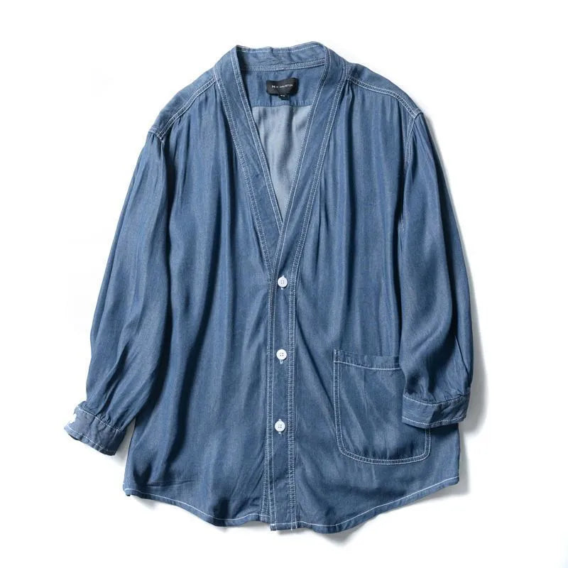 Men's dark blue V-neck denim coat with three-quarter sleeves showing loose fit and pocket detail