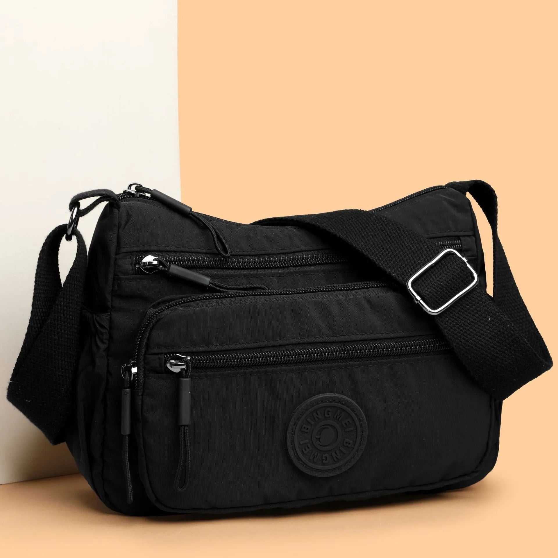 Water-repellent nylon crossbody cloth bag in black, grey or red with internal zipper compartments