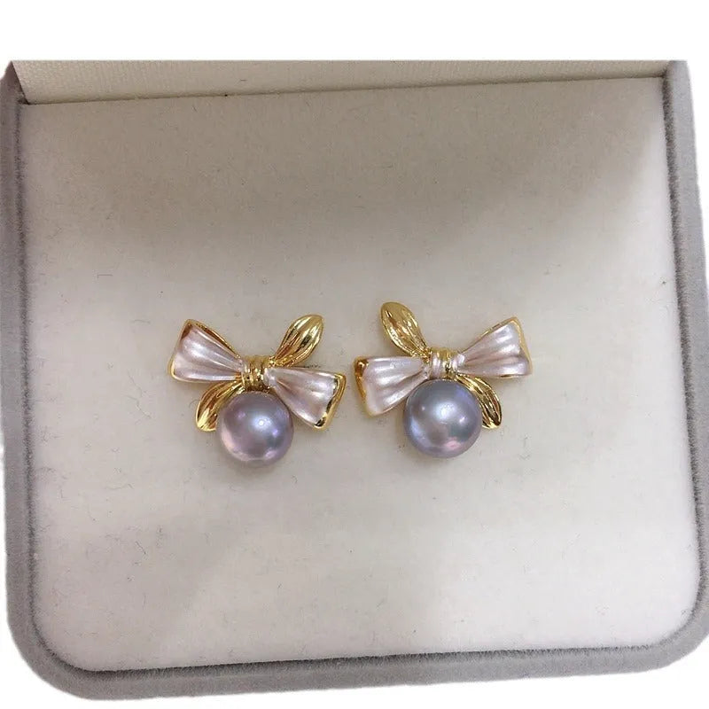 Two-tone bow pearl stud earrings in white or gray with flat circle shape