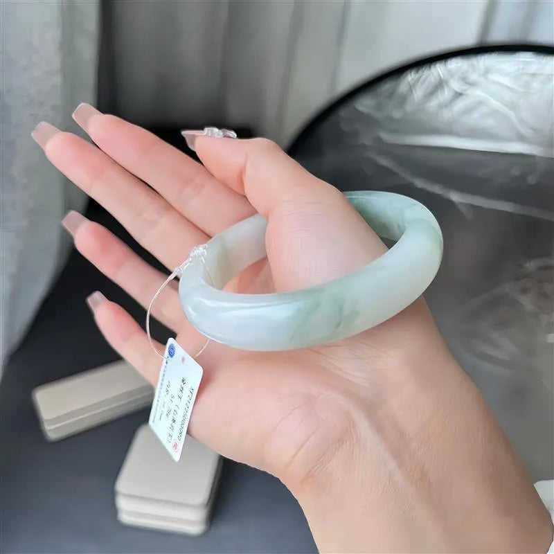 Tian Shan Cui bracelet with floating flower design and animal charm, showing icy clear mineral.