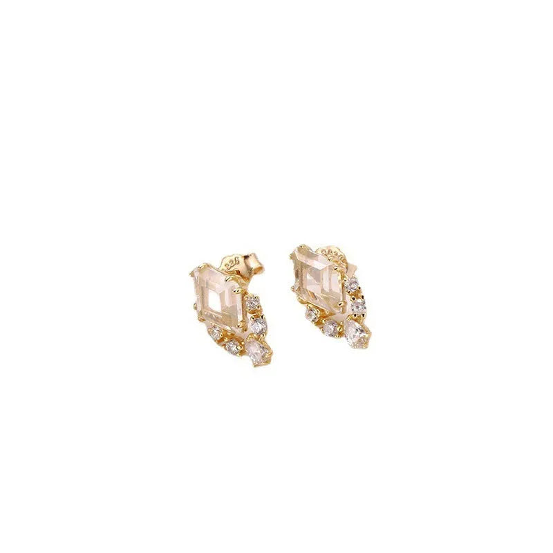 A pair of geometric sterling silver earrings with sweet white crystal studs on a white background.