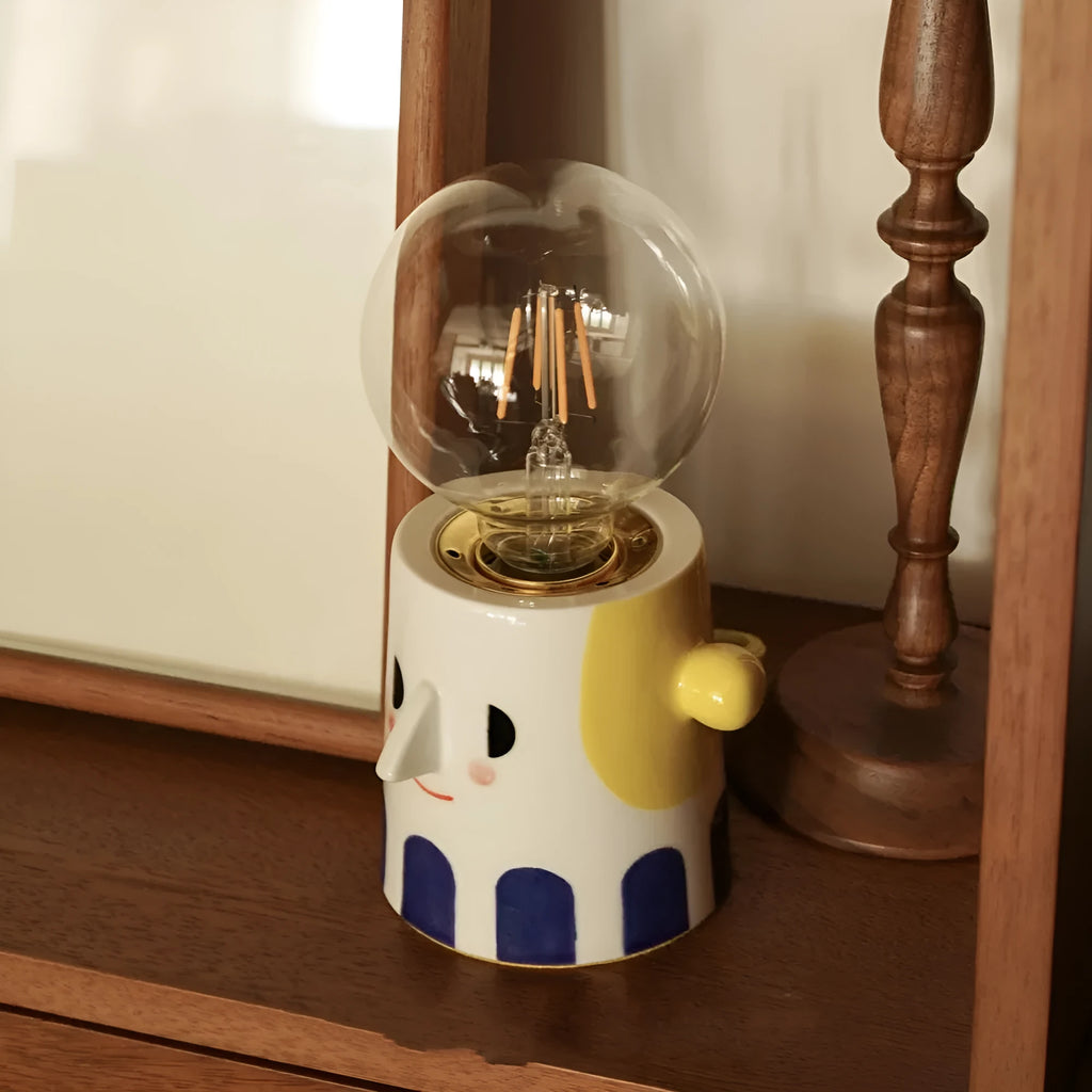 Handmade ceramic bedside lamp with ball headlight colour finish on a table.