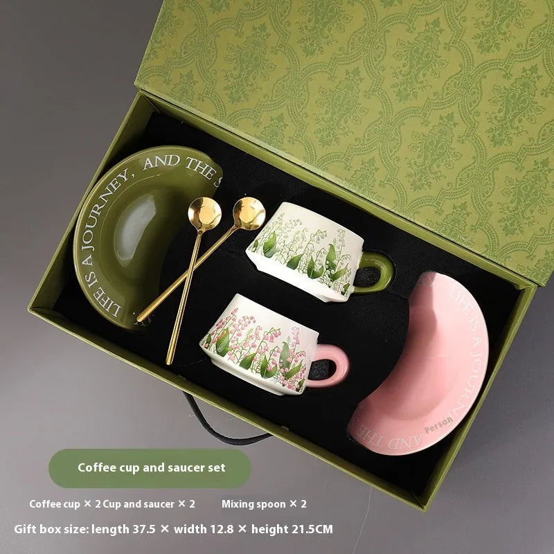 Ceramic coffee cup and saucer set with two cups, two saucers, and two stirring spoons