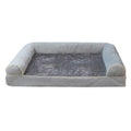 Square blue cloth dog bed with sponge filling on a wooden floor.