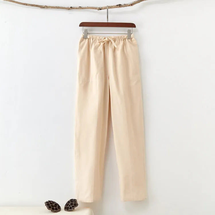 Men's beige pure cotton casual trousers with a drawstring waist on a hanger.