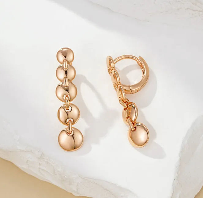 Gold-coloured retro woven round copper earrings showing textured circle design.