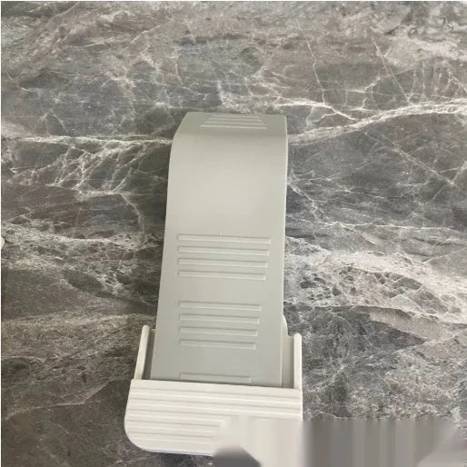 Gray rubber arch-shaped door stopper with a non-slip base on a light floor surface