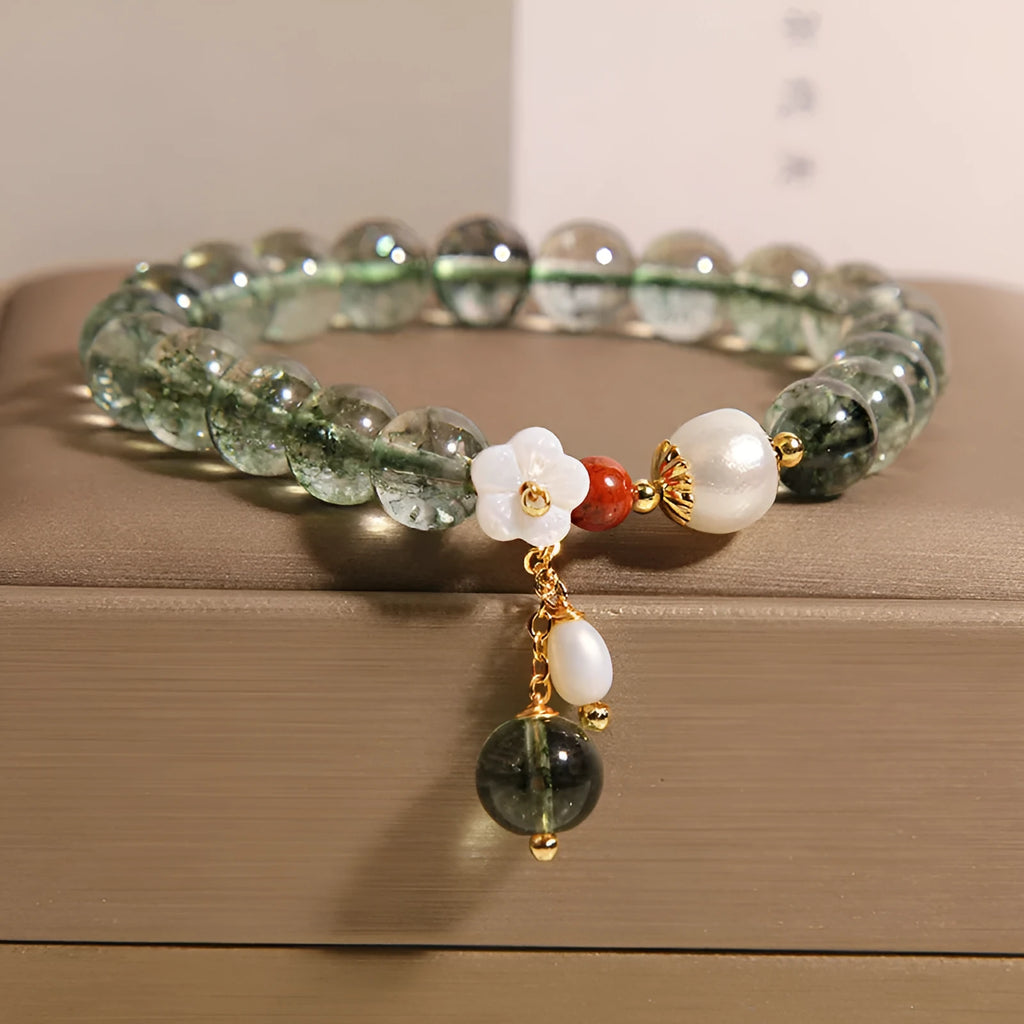 Green phantom quartz crystal bracelet with shell flower charms on wrist