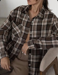 Dark brown striped women's long sleeve retro shirt on a hanger, showing collar and sleeve detail.