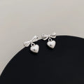 Thick silver-plated copper earrings with heart and bow design, light luxury style for women