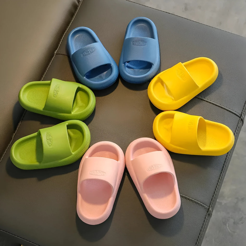 Colourful children's EVA slippers with a textured non-slip sole, shown in blue, green, orange, pink, and yellow.