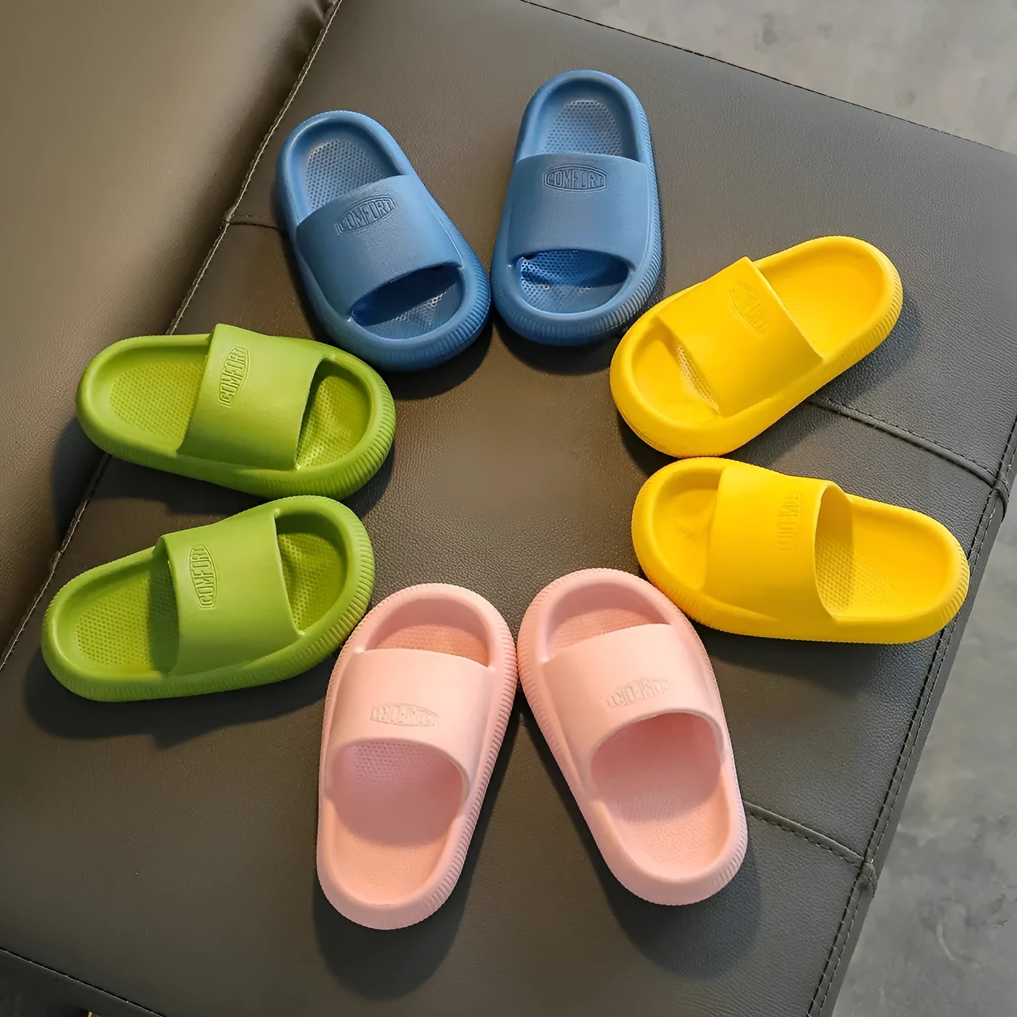 Colourful children's EVA slippers with a textured non-slip sole, shown in blue, green, orange, pink, and yellow.