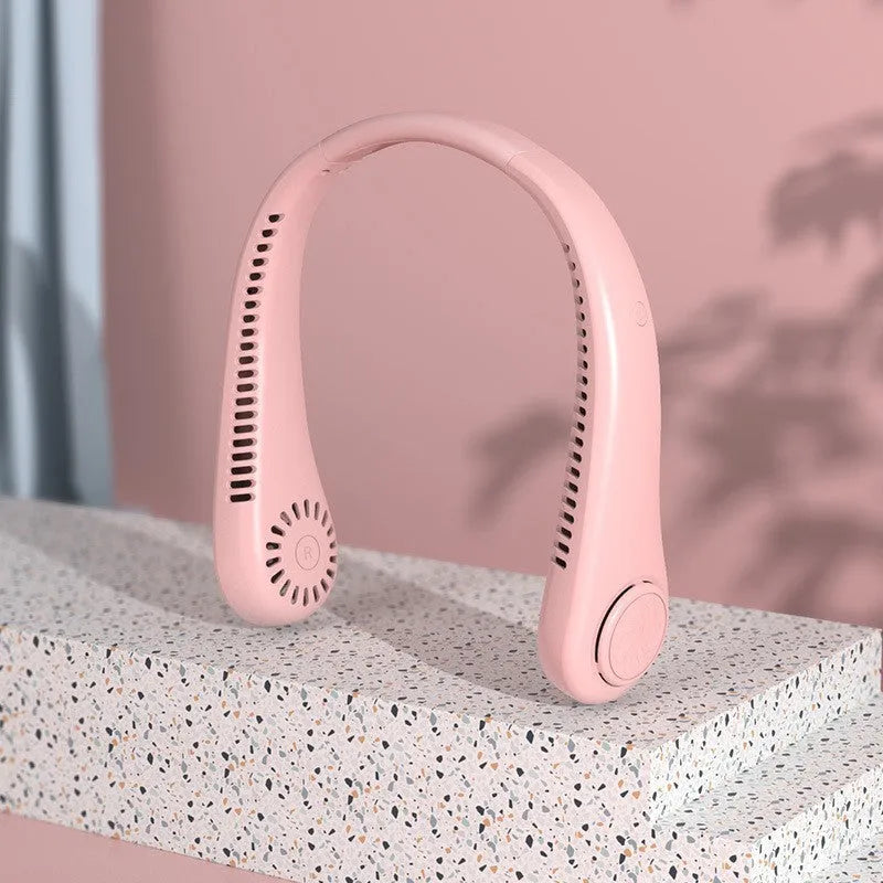 White portable bladeless neck fan hanging around a neck with USB charging cable.