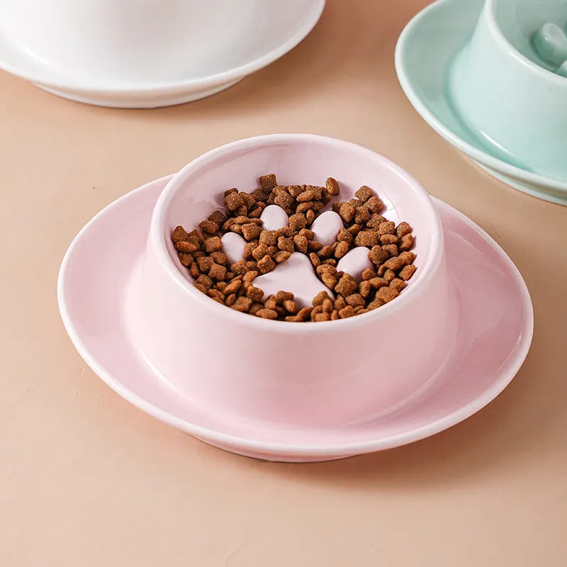 Green ceramic slow feeder pet bowl with internal maze pattern and raised basin design on a wooden floor.