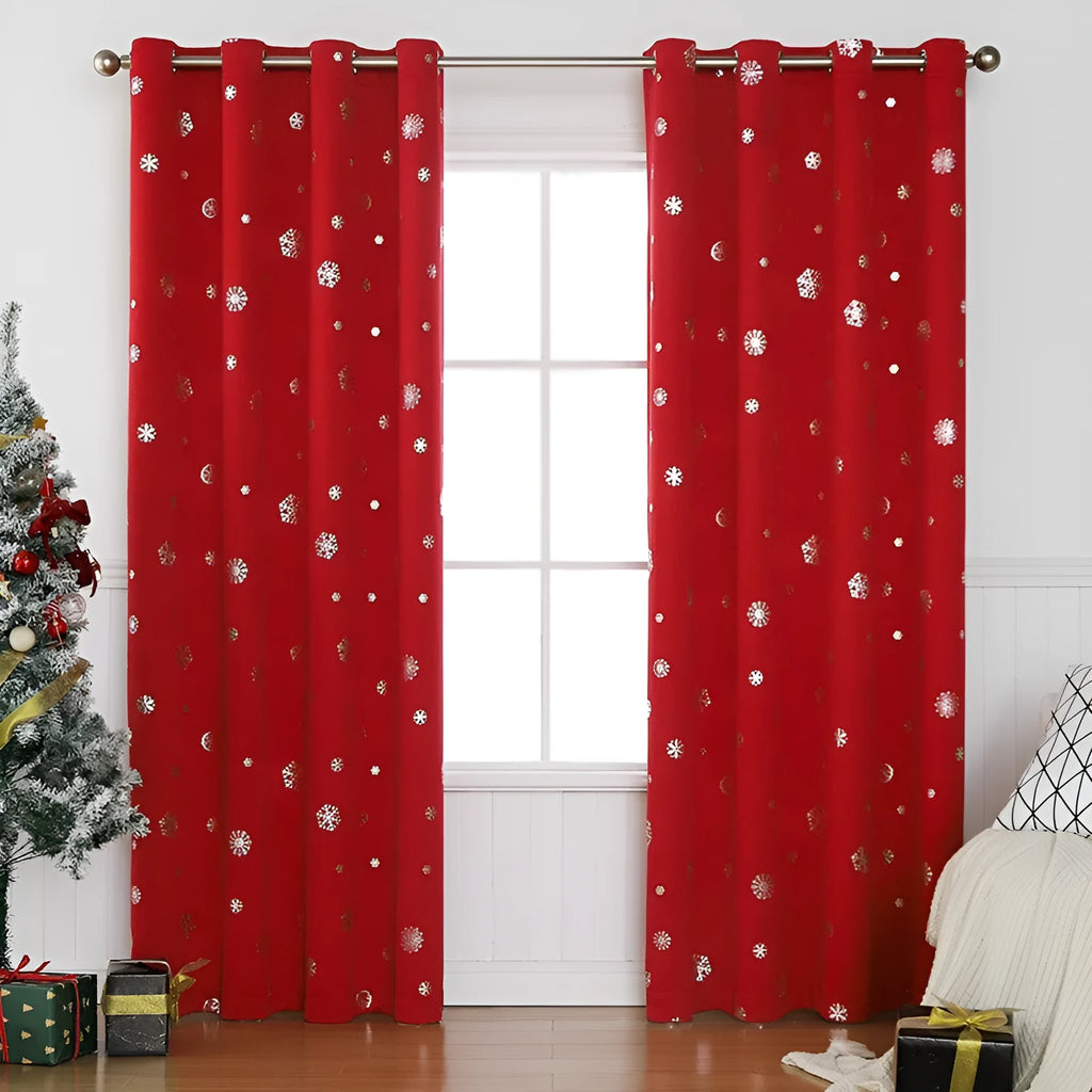 Red snowflake pattern shade cloth curtain with iron hoops hanging on a rod against a window.