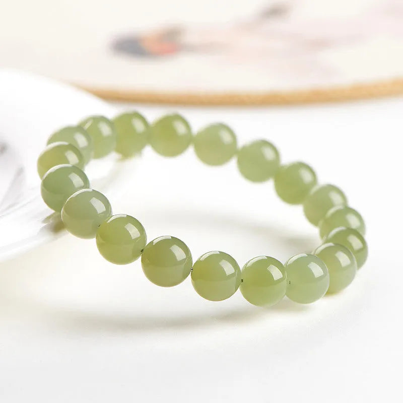 Polished Hetian jade bead bracelet in clear water colours on a wrist, showing bead size options.