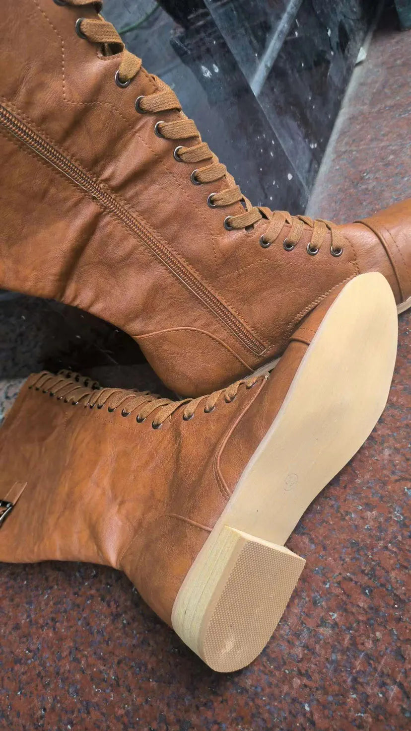 Women's black knight boots with a cross strap design on the shaft.