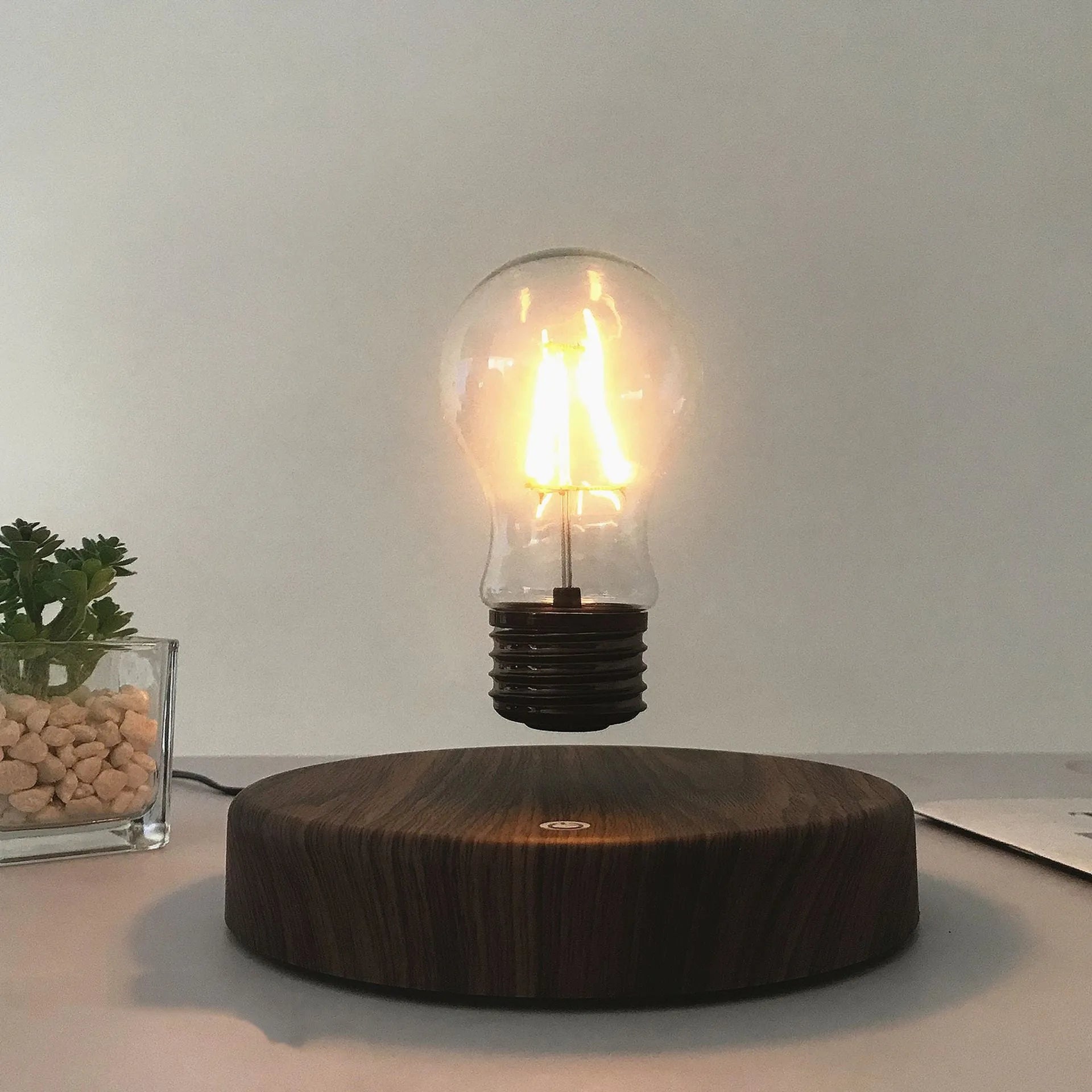 Magnetic levitation bulb night light in solid wood colour floating above plastic base