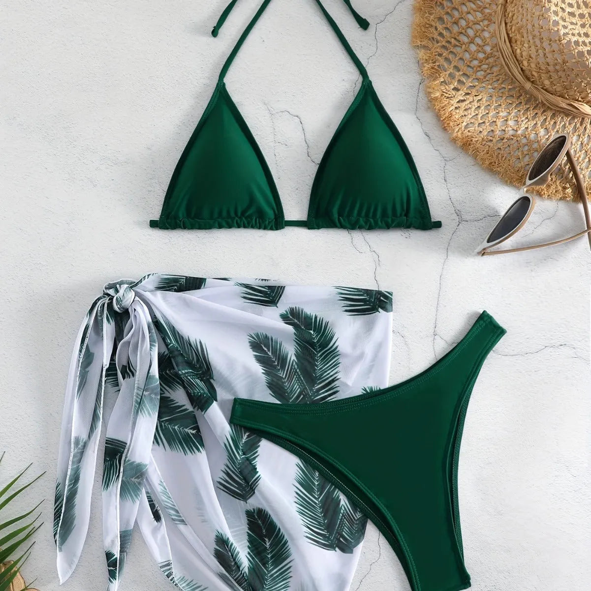 Women's orange three-piece bikini swimsuit set with a matching printed gauze skirt laid flat.