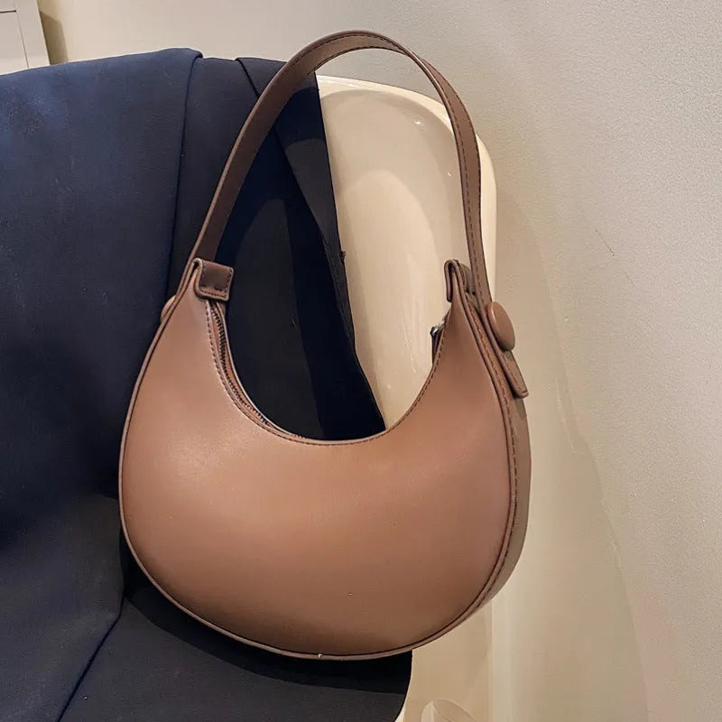 Women's retro brown PU dumpling shape shoulder bag with a front pocket shown.