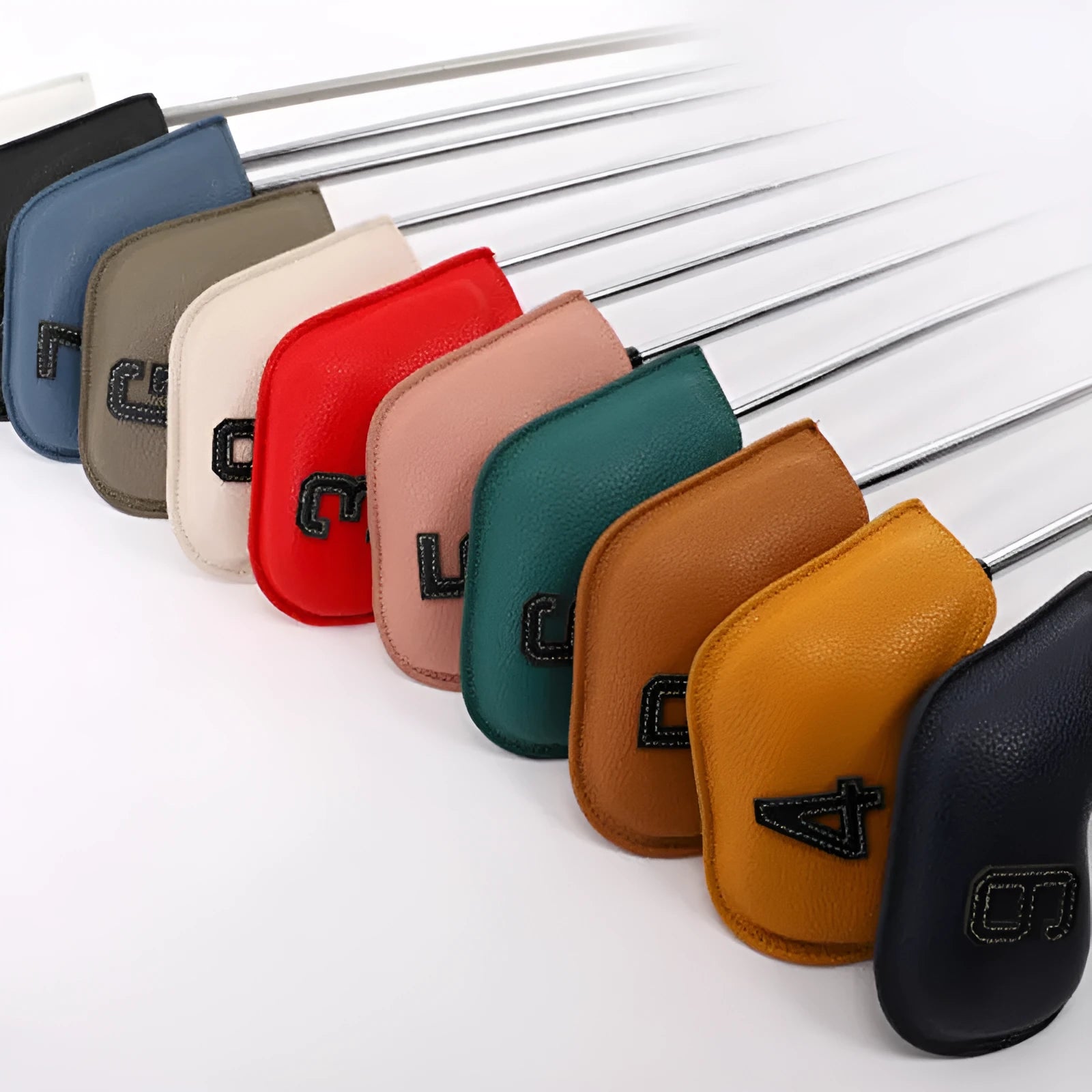 Set of 10 assorted coloured PU leather golf club head covers on a green background.