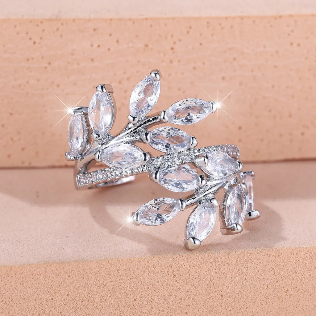 Adjustable copper leaf-shaped ring with zircon stone accents on a hand.