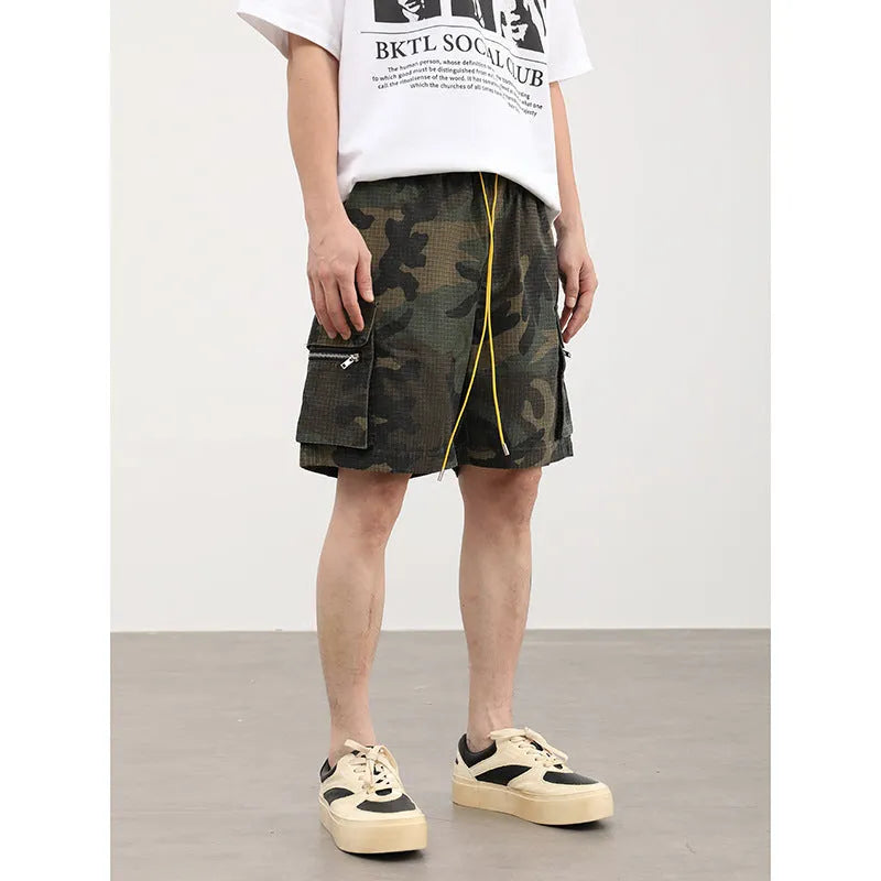 Men's camouflage cargo shorts showing multiple pockets and cropped leg length