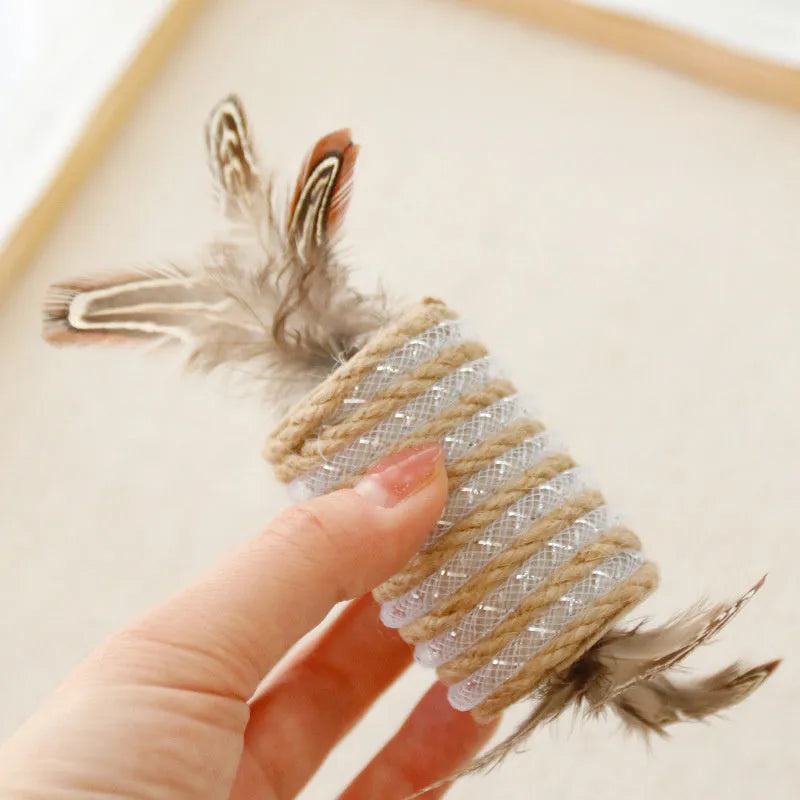 Beige cat toy with hemp rope scratching area, sound-making roller ball, and feather attachments.