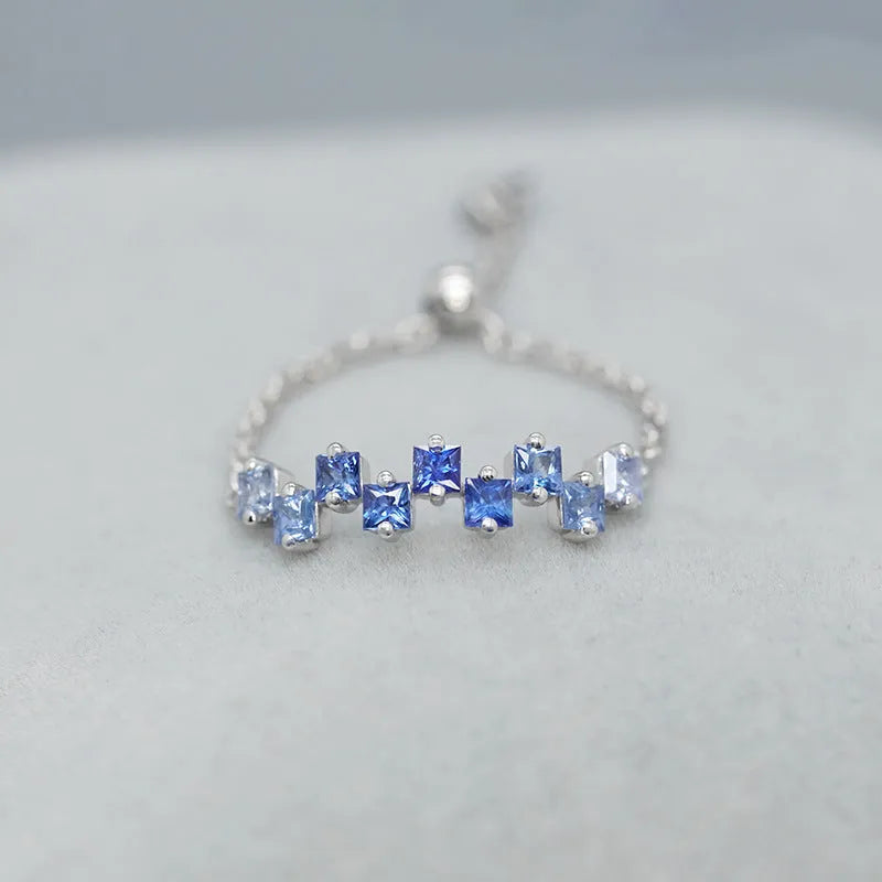 Square blue stone ring with adjustable copper band and floral leaf detailing in blue