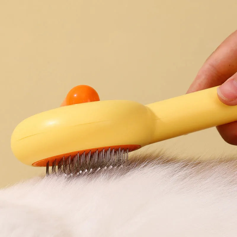 Small yellow and white pet grooming comb with needle teeth for cat and dog hair removal.
