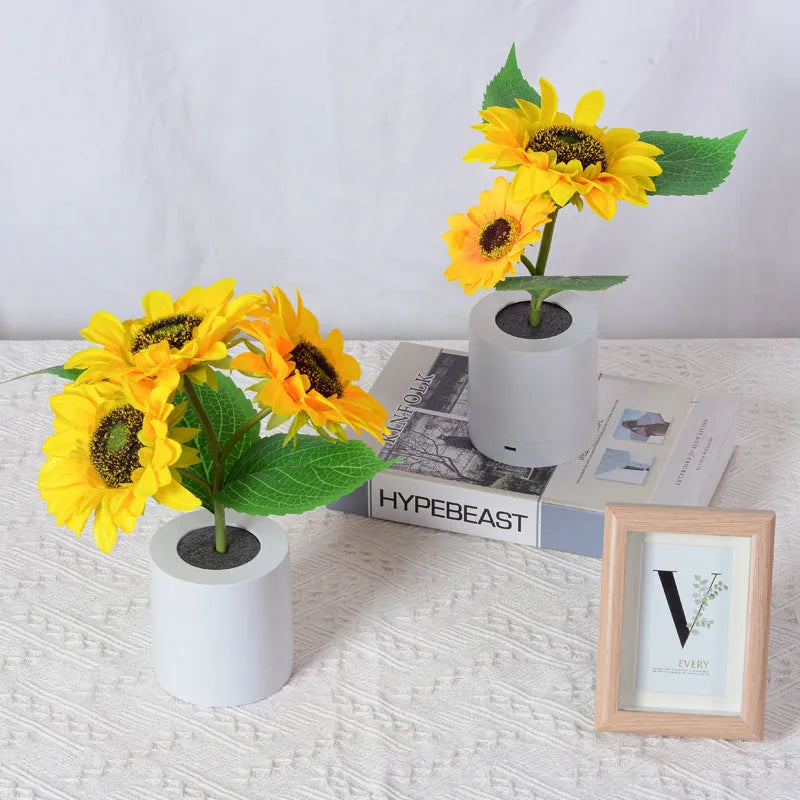 Rechargeable artificial sunflower LED night light on a table with USB cable.