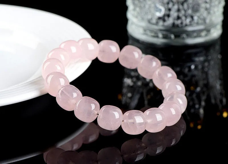 Pink crystal barrel bead bracelet with geometric design on a wrist.