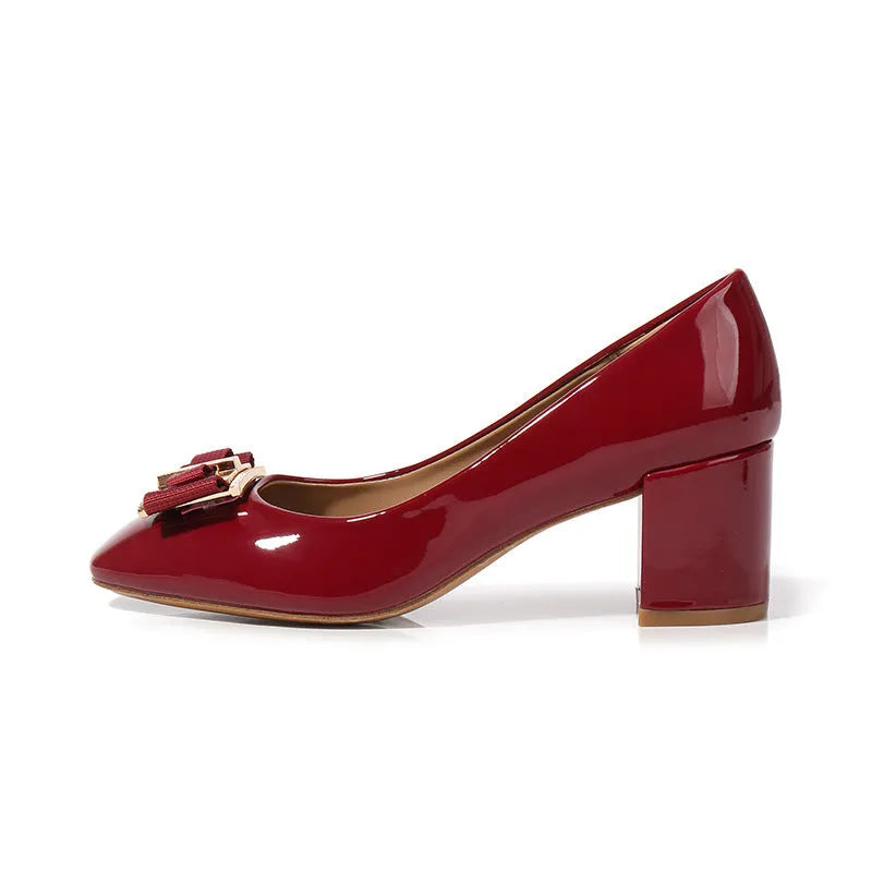 Mid heel round toe chunky heel pumps in solid colour with work buckle detail on a white background