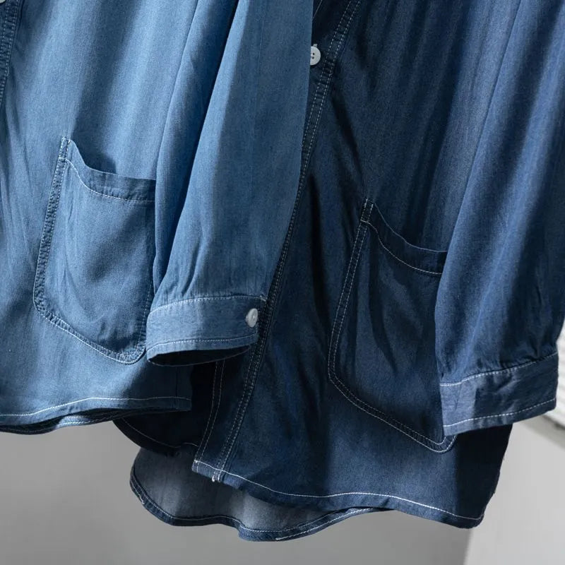 Men's dark blue V-neck denim coat with three-quarter sleeves showing loose fit and pocket detail