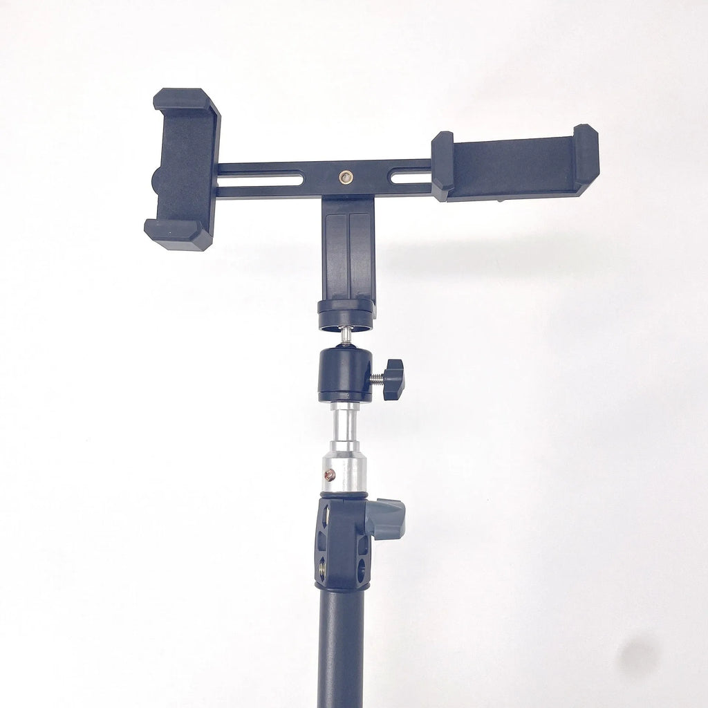 Black mobile phone tripod extended to 1.1m on a desk showing metal legs and phone mount