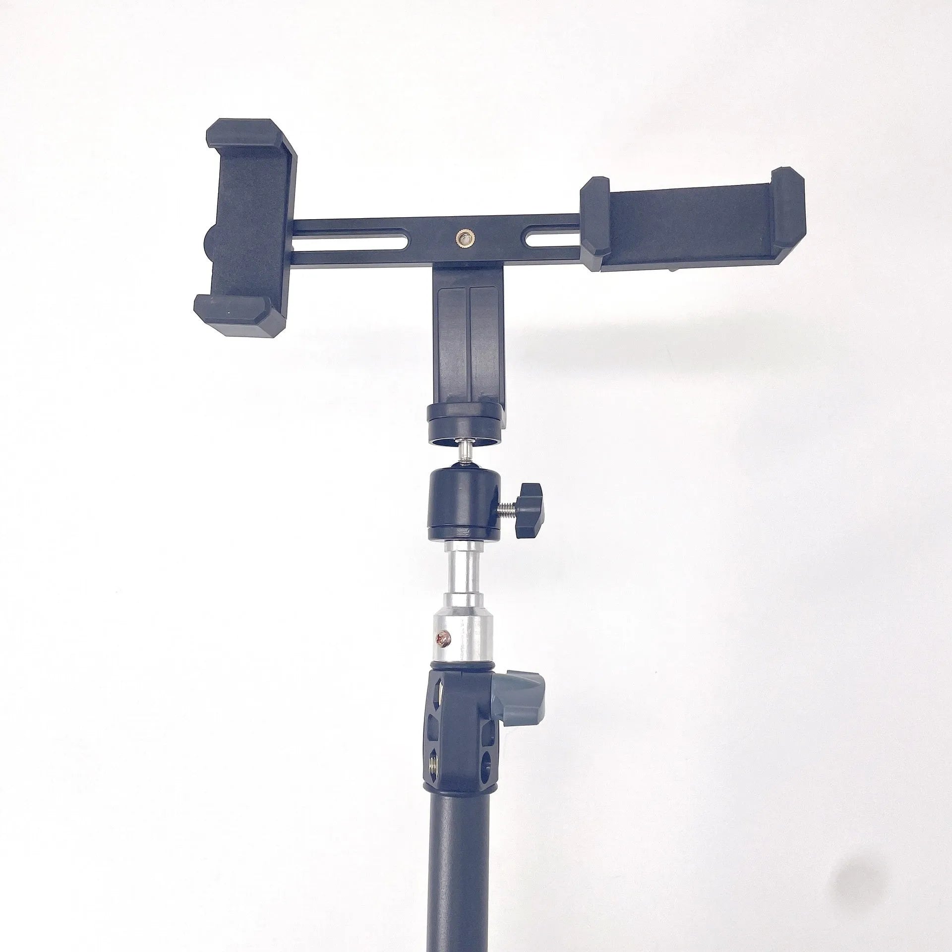 Black mobile phone tripod extended to 1.1m on a desk showing metal legs and phone mount