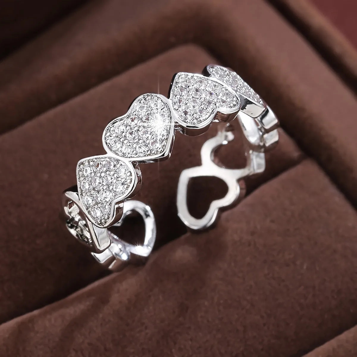 Gold or silver adjustable openable heart-shaped couples ring on a copper base.