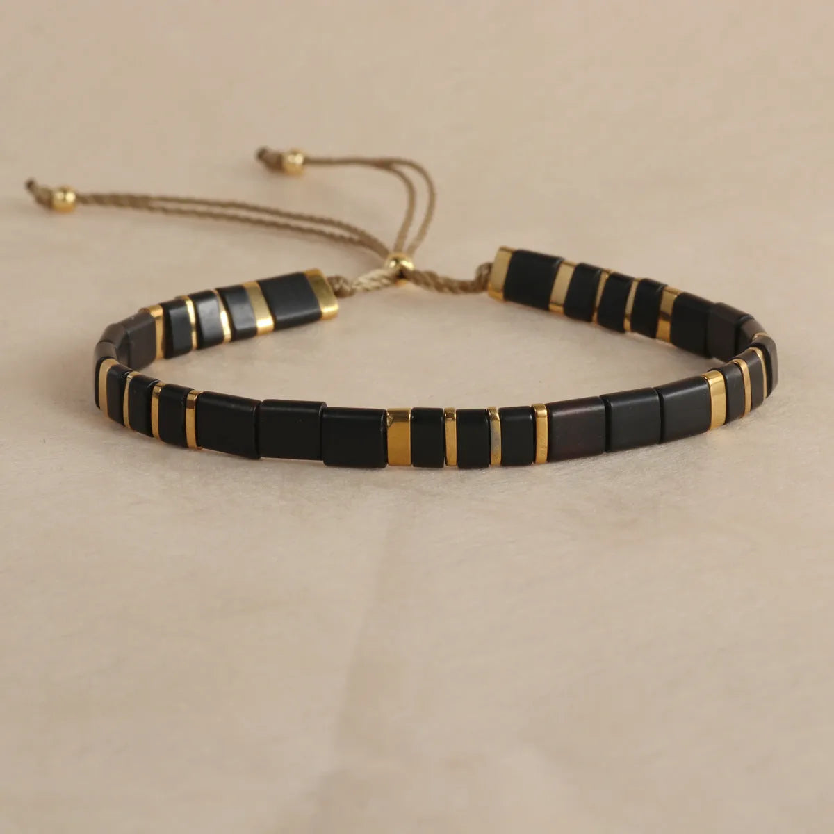 Geometric glass beaded bracelet in milky white, black, green, blue, or red on a plain background.