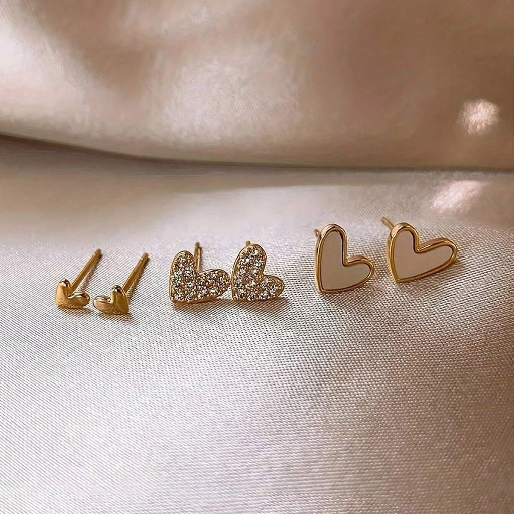 Three pairs of heart-shaped alloy earrings with electroplated finish in gold, black, pink or black and white