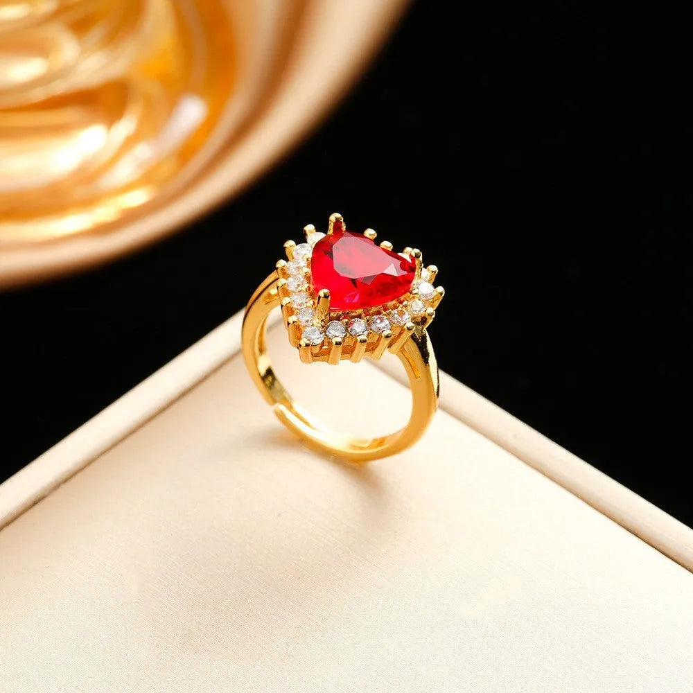 Gold red heart and flower pendant necklace, ear studs, and ring set made from titanium steel with gemstone inlays.