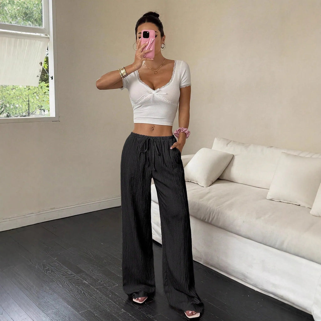 Women's black wide-leg trousers with a lace-up detail on the mid-rise waistband.