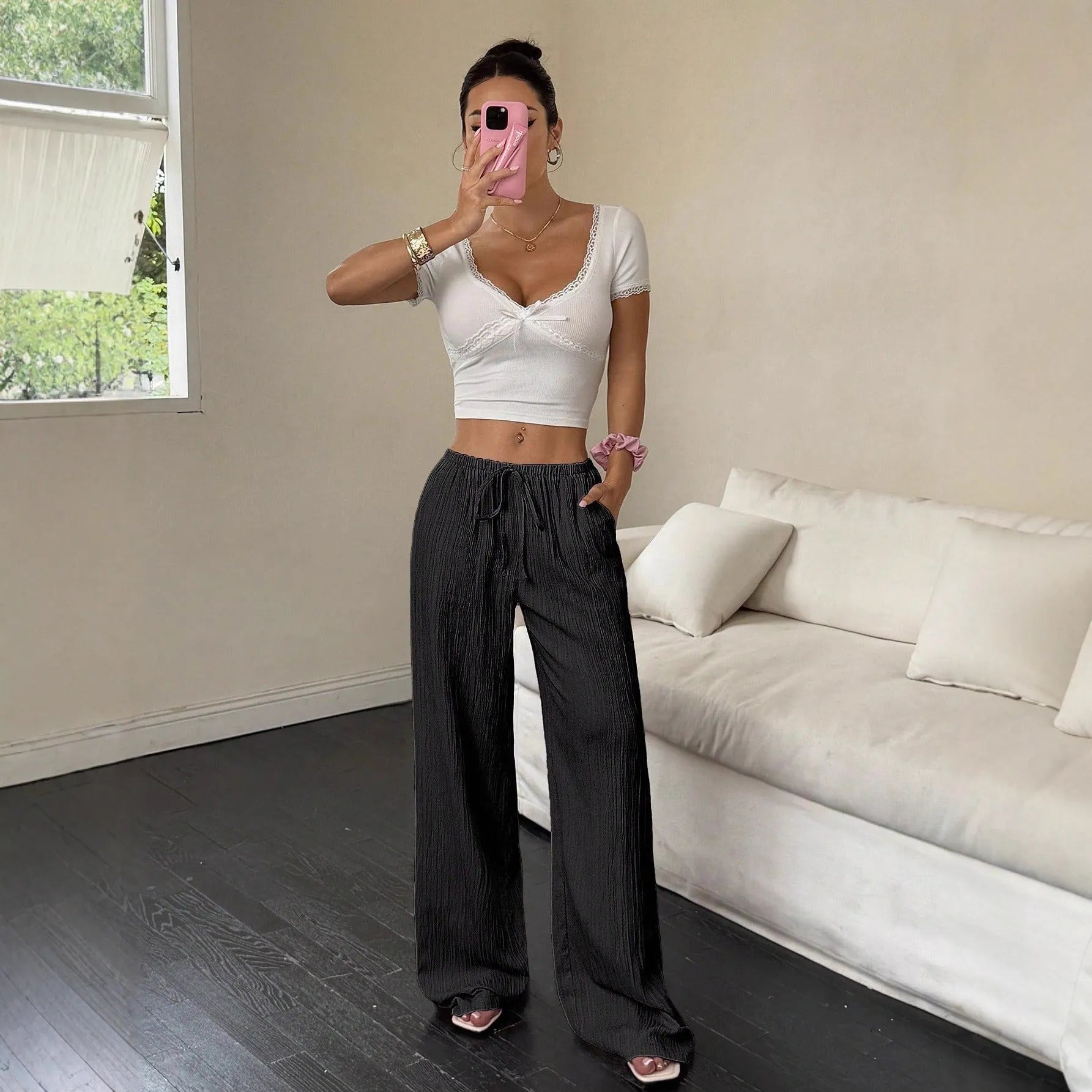 Women's black wide-leg trousers with a lace-up detail on the mid-rise waistband.