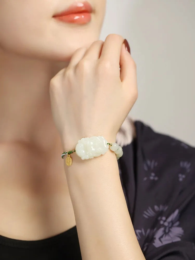 Year of the Rabbit Hetian jade charm bracelet with S925 silver detailing on a red cotton rope.