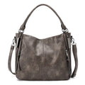 Soft PU crossbody shoulder bag in khaki with metal accent and double strap connectors on a white background