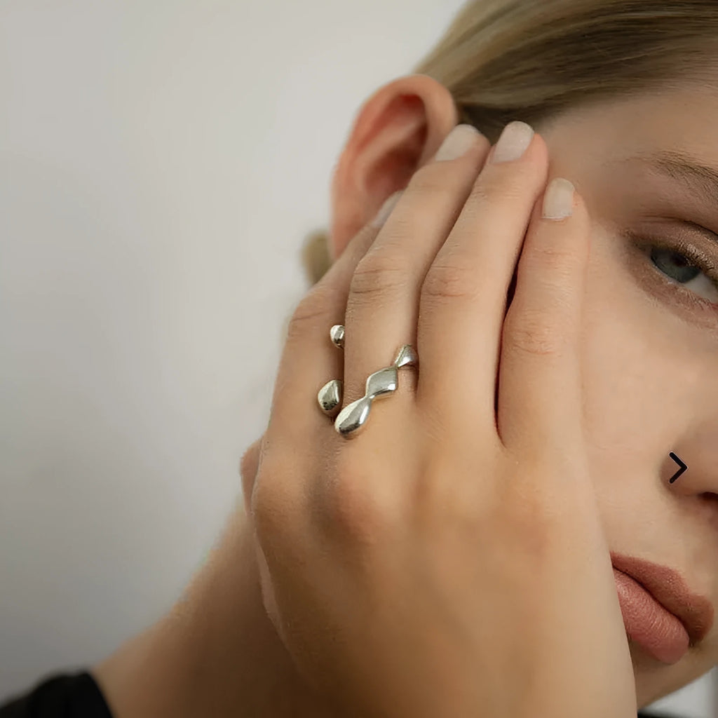 Gold and silver adjustable opening fashion ring with spherical design on a brass base.