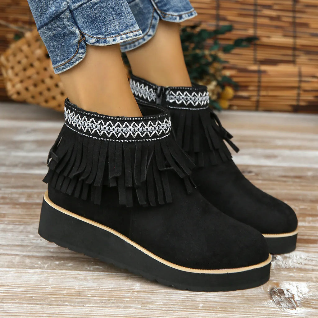 Women's black suede wedge ankle boots with a side zip and tassel detail on a thick rubber sole.